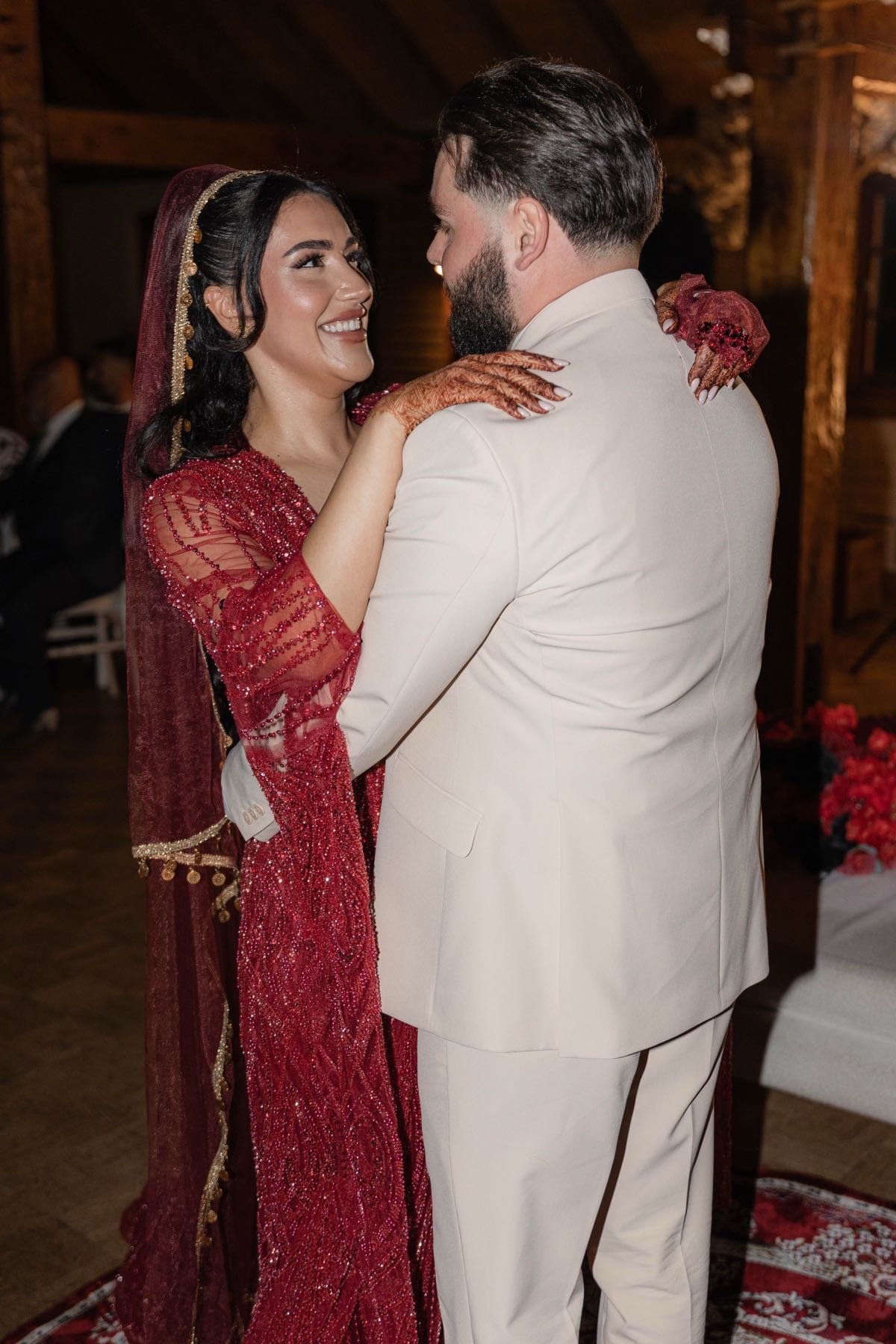 Bruidspaar in rode en crèmekleurige kleding danst op de henna-avond